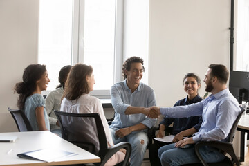 Cheerful confident business colleagues men shaking hands with recognition, acknowledgement,...