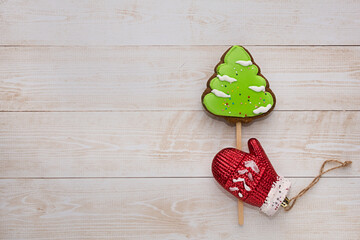 Gingerbread and Christmas tree decorations lie on a wooden background. There is space for text. Christmas background for congratulations and cards