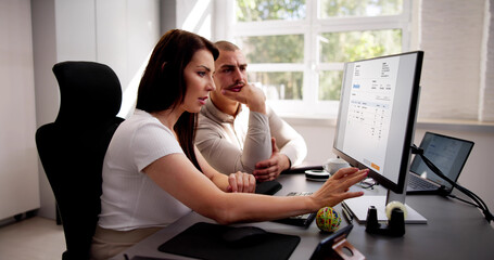 Business People Calculating Tax Together At Desk
