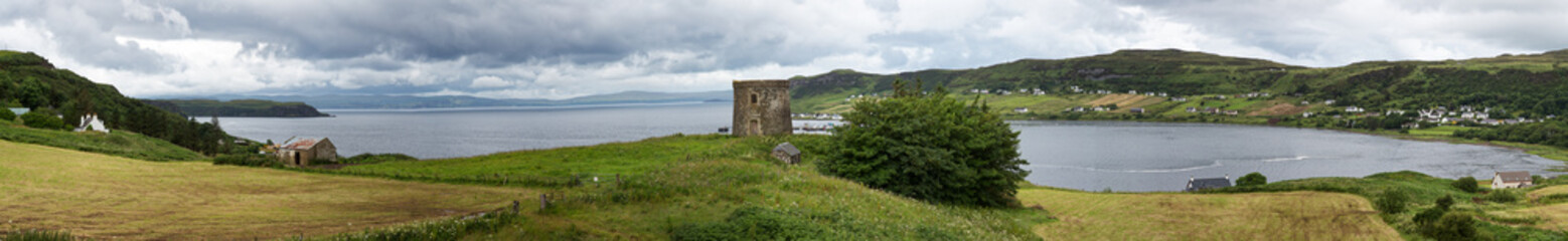 Fototapeta na wymiar Uig bay panorama, with the Uig Tower, a 19th century folly. and the village beyond. Isle of Skye, Highlands of Scotland.