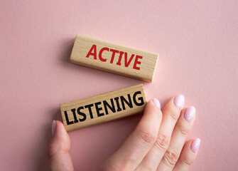 Active listening symbol. Wooden blocks with words Active listening. Businessman hand. Beautiful pink background. Business and Active listening concept. Copy space.