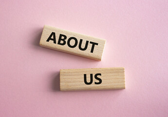 About us symbol. Concept word About us on wooden blocks. Beautiful pink background. Business and About us concept. Copy space