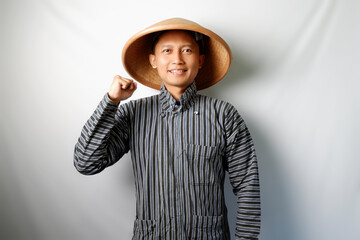 Happy Asian farmer standing and looking at camera with clenched fist isolated on white background