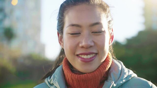Portrait of an attractive Asian Chinese woman happy smiling and laughing looking at camera. High quality 4k footage