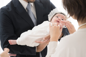 赤ちゃんを抱っこする父母お宮参りなど　クローズアップ　両親の顔無し