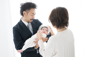赤ちゃんを抱っこする両親　お宮参りなど