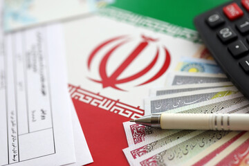 Iranian annual income tax return form F20-25-006 ready to fill on table with pen, calculator and...