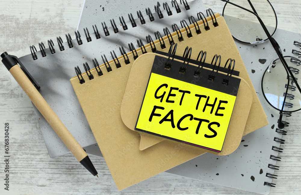 Poster get the facts text on a yellow sticky note on a gray notepad on the table