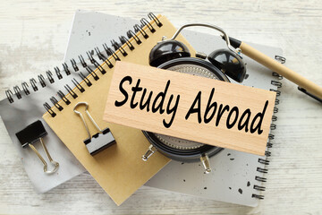 Study Abroad a wooden block with text lies on the table clock