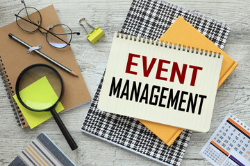 Event management Concept. text on the page on a bright notebook. glasses and magnifying glass on a...