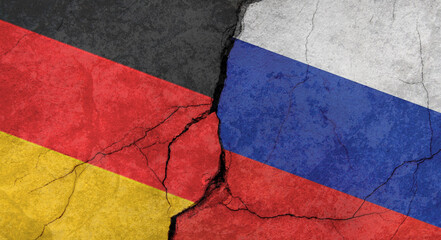 Flags of Germany and Russia, texture of concrete wall with cracks, orange background, military conflict concept