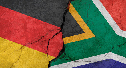 Germany and South Africa flags, concrete wall texture with cracks, grunge background, military conflict concept
