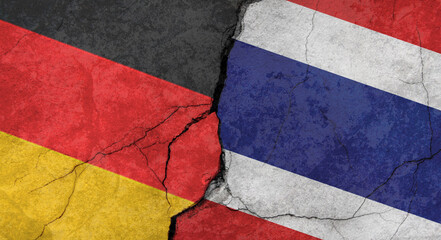 Germany and Thailand flags, concrete wall texture with cracks, orange background, military conflict concept - obrazy, fototapety, plakaty