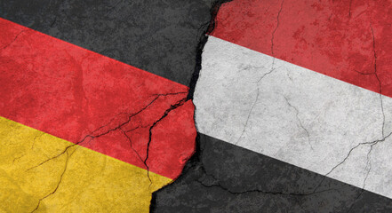 Germany and Yemen flags, concrete wall texture with cracks, grunge background, military conflict concept