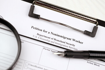 I-129 Petition for a nonimmigrant worker blank form on A4 tablet lies on office table with pen and...