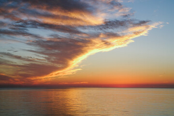 Naklejka na ściany i meble orange cloudy sunset sky view from the sea