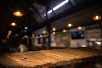 image of wooden table in front of abstract blurred background of resturant lights . High quality photo