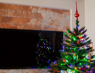 Large TV in a room with a Christmas tree....