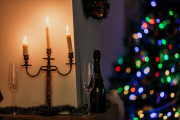 Candles and champagne. New Year lights in back..
