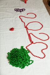 Number 202 laid out of red beads on white background..