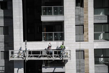 Construction workers on a lift platform work