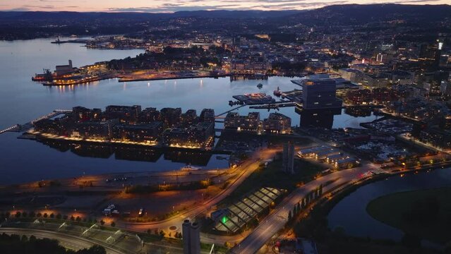 High angle view of residential neighborhood on Oslo fjord bank at dusk. Tilt up reveal evening cityscape. Oslo, Norway
