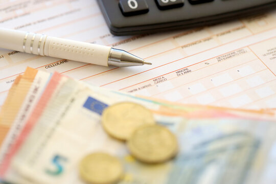 Filling italian tax form process with pen, calculator and euro money bills close up. Tax paying period and deadline