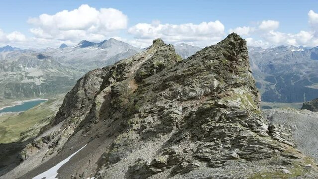 Drone turning around a scenic rocky peak crest in Val Loga Montespluga Italian Alps