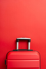 Festive adventure concept. Top view vertical photograph of trendy red suitcase on a red background,...