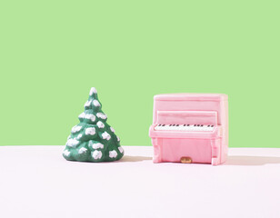 Piano pink color and Christmas tree on the stage. Minimal holiday concept.