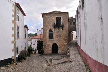 Fototapeta na wymiar Cidade medieval de Óbidos em Portugal, bifurcação de uma rua com um edifício antigo ao meio
