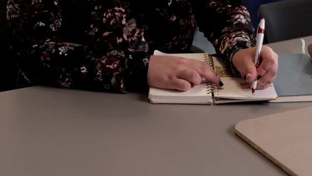 Close-up view of a woman writing in a notebook
