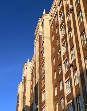 Vertical shot of a brick building facade against a blue sky