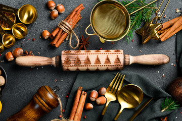 Kitchen wooden rolling pin. Christmas decoration style. dark background. Top view.
