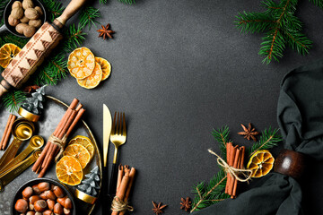 Christmas card. background with Christmas winter spices and ingredients for baking on a dark slate.