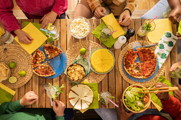 Family or friends celebrating. having pizza for dinner. Shot of people hands on a rustic wooden...