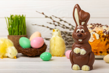 Easter chocolate bunny on a light texture table. Chocolate eggs and other sweets. Easter celebration concept. Easter sweets on the table. Place for text. copy space.