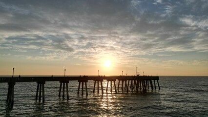 Fototapeta na wymiar Beautiful sunset over a pier in the sea.