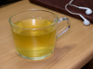 A cup of tea on wooden table with gadgets in the background