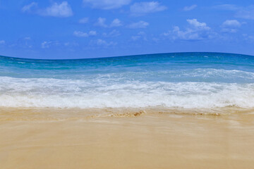 Fototapeta na wymiar Light blue sea waves on clean sandy beach, Tropical white sand beach and soft sunshine background