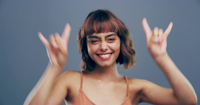 Rock hand gesture, face or woman in studio on grey background for freedom, energy or emoji. Smile, confident model or portrait of happy person isolated for devil horns sign, punk or edgy attitude