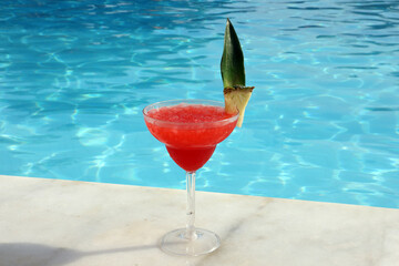 Beautiful glass with a refresh cocktail on the background of the swim pool.