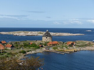 Fototapeta na wymiar Aerial shot of a stone building on the coastline of Bornholm Island with clouds in the background