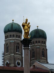Fototapeta na wymiar Munich Frauenkirche buildings behind golden statue