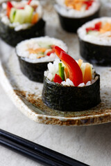 Homemade futomaki maki sushi rolls on a plate. Close-up view.