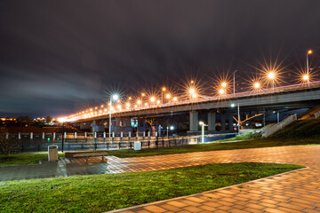 Road bridge at night, beautiful glare of light from street lamps. Cityscape in the evening.