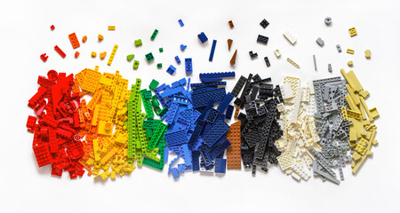 Fototapeta premium Pile of colorful rainbow toy bricks isolated on white background. Education concept. Lego blocks. Novosibirsk, Russia - October 26, 2023.
