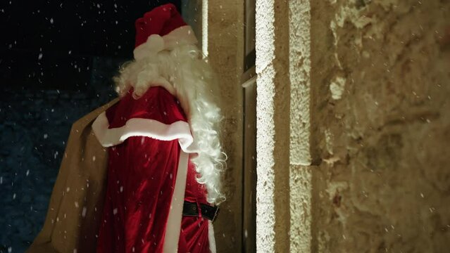 Santa Claus entering an old House for Christmas 
