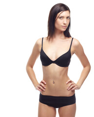 Fototapeta premium Young woman, portrait and underwear in lose weight, slim body or diet against a white studio background. Attractive female person or model in lingerie, bikini or posing for detox, health and wellness