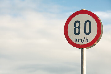 Travel concept. Information board on road. Speed limitation 80 km/h sign. Close up. Text space. Outdoor shot